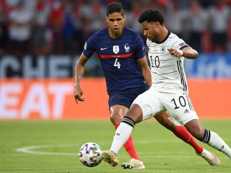 MUNICH, GERMANY - JUNE 15: Serge Gnabry of Germany is closed down by Raphael Varane of France during the UEFA Euro 2020 Championship Group F match between France and Germany at Football Arena Munich on June 15, 2021 in Munich, Germany. (Photo by Matthias Hangst/Getty Images)