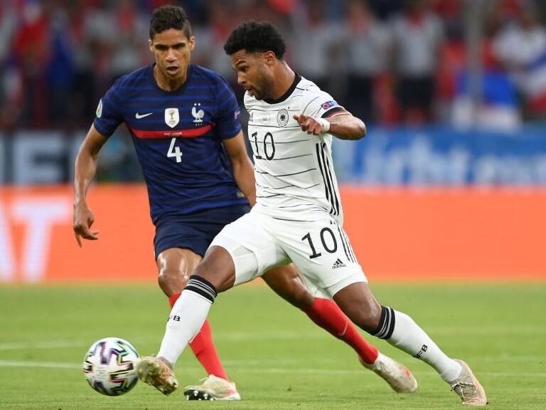 MUNICH, GERMANY - JUNE 15: Serge Gnabry of Germany is closed down by Raphael Varane of France during the UEFA Euro 2020 Championship Group F match between France and Germany at Football Arena Munich on June 15, 2021 in Munich, Germany. (Photo by Matthias Hangst/Getty Images)