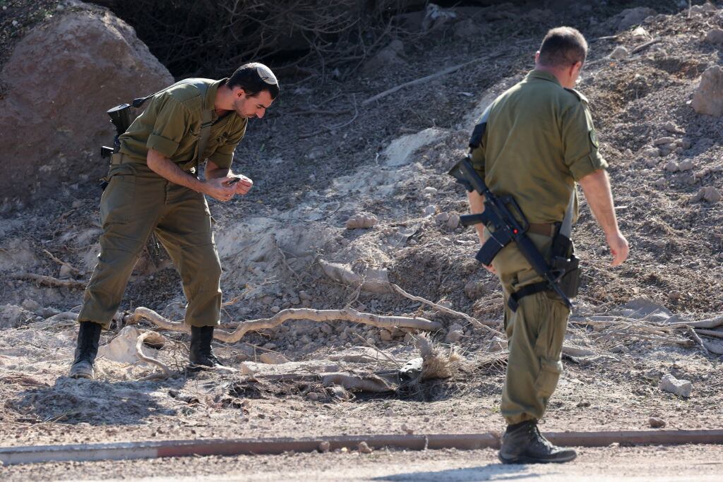 Soldados de Israel revisan la zona en que un cohete lanzado por Hezbolá impactó en los alrededores de la ciudad de Tel Aviv