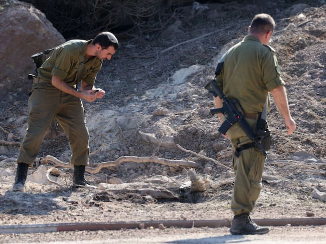 Soldados de Israel revisan la zona en que un cohete lanzado por Hezbolá impactó en los alrededores de la ciudad de Tel Aviv