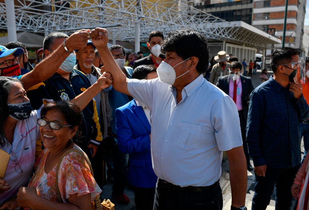 Evo Morales con mascarilla saludando a adeptos