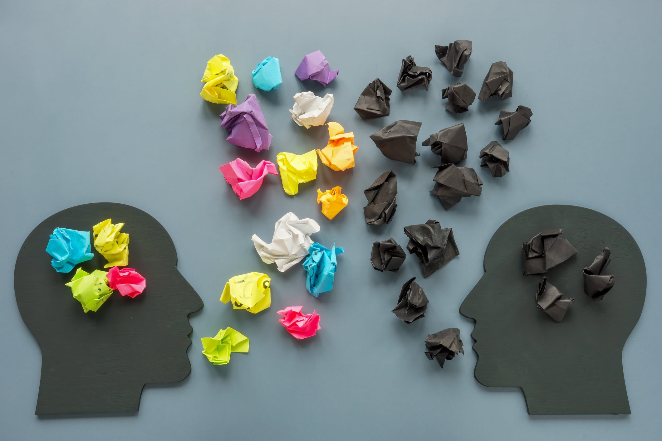 Positive and negative thinking concept. Figures of heads and paper balls.