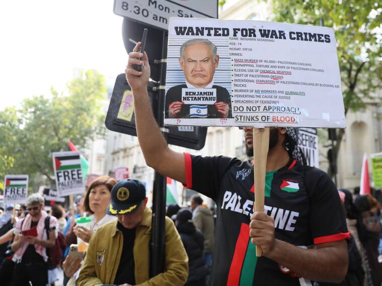 Manifestante porta un cartel que pide la detención de Benjamin Netanyahu por crímenes de guerra durante una manifestación en Londres de Inglaterra