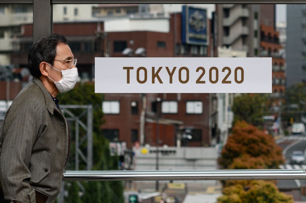 Un hombre utiliza una máscara al caminar por Tokio