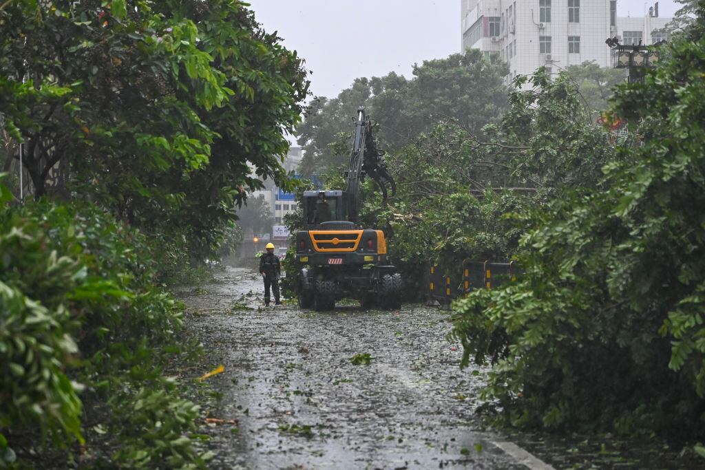 Los trabajadores en la ciudad de Zhanjiang, de la provincia de Hainan, intentan despejar los caminos tras el arribo del supertifón Yagi a China