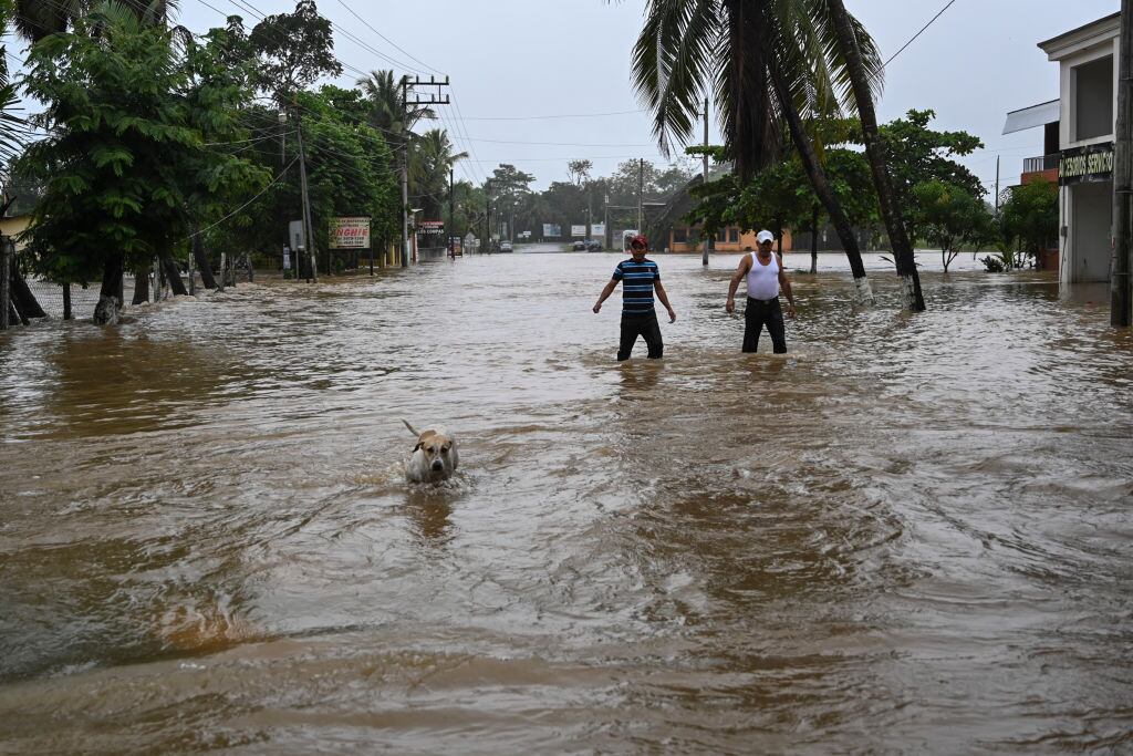 Dos personas caminan por una calle inundada en el municipio de Morales
