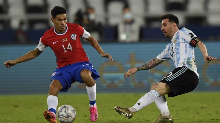 TOPSHOT - Chile's Pablo Galdames (L) and Argentina's Lionel Messi vie for the ball during their Conmebol Copa America 2021 football tournament group phase match at the Nilton Santos Stadium in Rio de Janeiro, Brazil, on June 14, 2021. (Photo by MAURO PIMENTEL / AFP) (Photo by MAURO PIMENTEL/AFP via Getty Images)