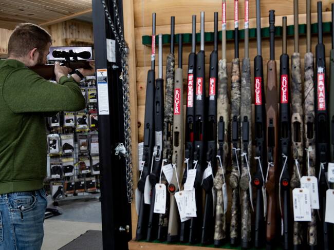 Un hombre revisa un arma para comprarla en una tienda en Ottawa