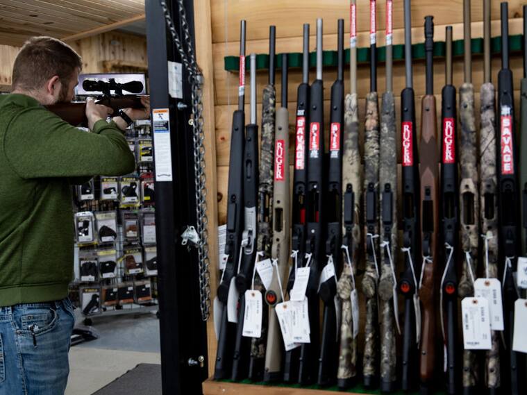 Un hombre revisa un arma para comprarla en una tienda en Ottawa