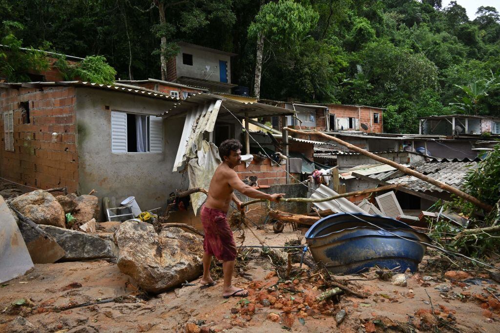 Hombre busca entre los escombros tras las lluvias en el estado de Sao Paulo