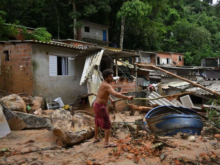 Hombre busca entre los escombros tras las lluvias en el estado de Sao Paulo