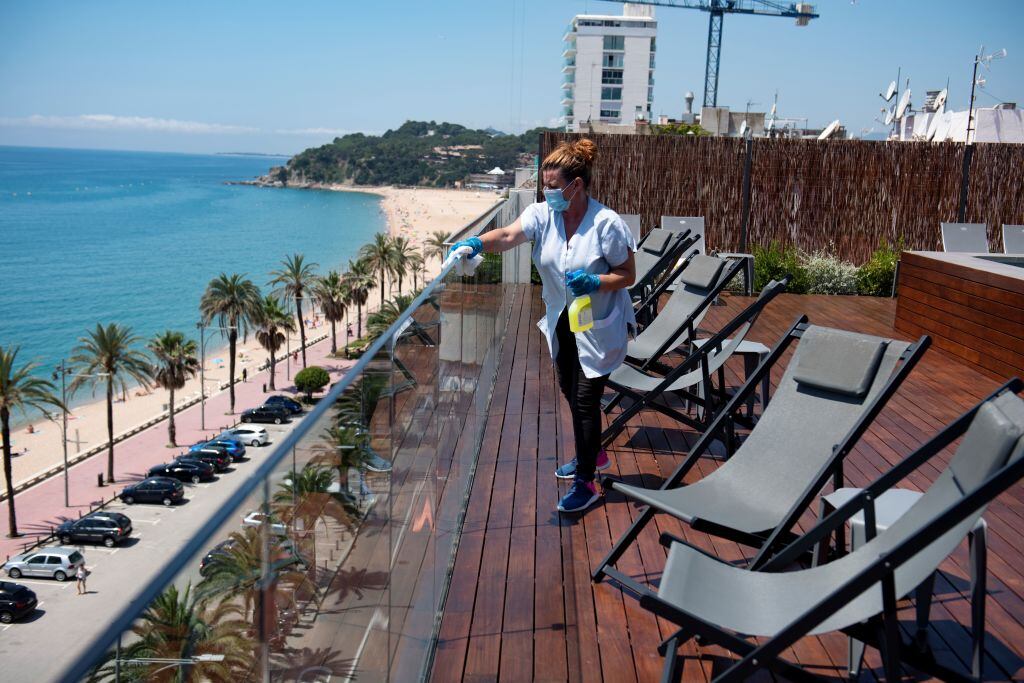Trabajadora limpia la terraza de un hotel vacío en España