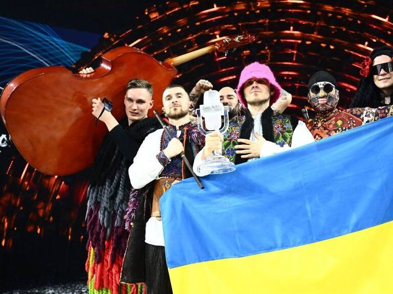 Members of the band "Kalush Orchestra" pose onstage with the winner's trophy and Ukraine's flags after winning on behalf of Ukraine the Eurovision Song contest 2022 on May 14, 2022 at the Pala Alpitour venue in Turin. (Photo by Marco BERTORELLO / AFP) (Photo by MARCO BERTORELLO/AFP via Getty Images)