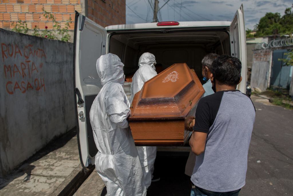 Trabajadores trasladan el féretro de una victima del Covid-19 en Manaos