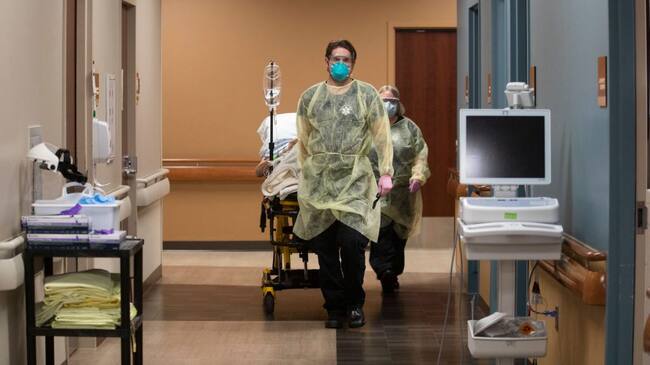 JAMESTOWN, ND - NOVEMBER 22: Kevin Bousquet, Jamestown Area Ambulance EMT wheels out a patient inside the emergency department at Jamestown Regional Medical Center, on Sunday, Nov. 22, 2020 in Jamestown, ND. In the course of a day, the ER staff had seen 29 patients, including five with COVID-19. They had also treated a cat bite, lacerations, bruises from domestic violence, an ankle injury and a dislocated shoulder. At the end of the 12-hour shift, hospital staff wheeled a COVID patient out of the double doors and loaded him into an ambulance. Hes got a lot of medical issues, Nikole Hoggarth, RN said. Hes from a nursing home. The night he came in here we put him on a BiPap, she said, referring to a machine that helps breathing. Jamestown Regional Medical Center had done all it could for them man. The ambulance departed on a 100-mile trip east to Fargo, a bigger hospital. (Francine Orr / Los Angeles Times via Getty Images)