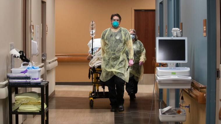 JAMESTOWN, ND - NOVEMBER 22: Kevin Bousquet, Jamestown Area Ambulance EMT wheels out a patient inside the emergency department at Jamestown Regional Medical Center, on Sunday, Nov. 22, 2020 in Jamestown, ND. In the course of a day, the ER staff had seen 29 patients, including five with COVID-19. They had also treated a cat bite, lacerations, bruises from domestic violence, an ankle injury and a dislocated shoulder. At the end of the 12-hour shift, hospital staff wheeled a COVID patient out of the double doors and loaded him into an ambulance. Hes got a lot of medical issues, Nikole Hoggarth, RN said. Hes from a nursing home. The night he came in here we put him on a BiPap, she said, referring to a machine that helps breathing. Jamestown Regional Medical Center had done all it could for them man. The ambulance departed on a 100-mile trip east to Fargo, a bigger hospital. (Francine Orr / Los Angeles Times via Getty Images)