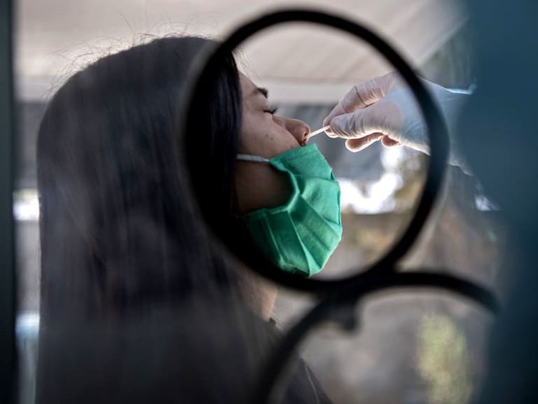 A woman undergoes a PCR test for the novel coronavirus at the mobile medical center of the municipality of El Bosque, in Santiago on August 25, 2020. - After critical weeks in May and June, Chile managed to keep the new cases of coronavirus stable in most of the country. To avoid upsurges, it is now investing efforts to continue testing massively and to reinforce traceability, the key link to lift quarantines. (Photo by MARTIN BERNETTI / AFP) (Photo by MARTIN BERNETTI/AFP via Getty Images)