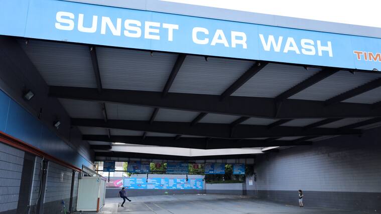 LOS ANGELES, CALIFORNIA - APRIL 15: A man and boy play soccer in a car wash which is currently shuttered due to the coronavirus pandemic on April 15, 2020 in Los Angeles, California. The man said they have begun to play there because some nearby parks have been closed due to the spread of COVID-19. (Photo by Mario Tama/Getty Images)
