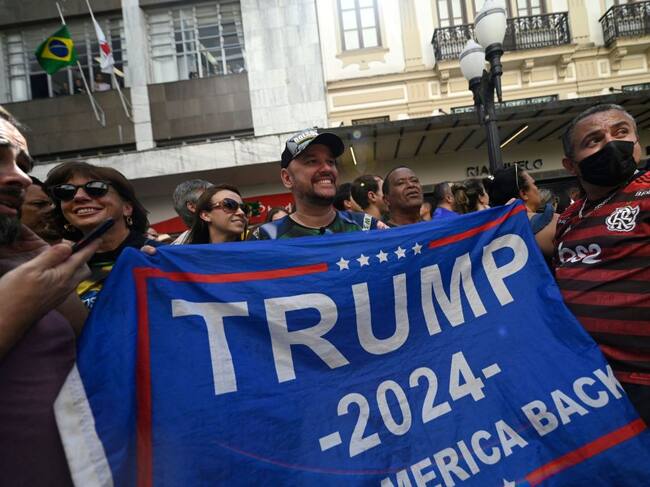 Fanáticos de Jair Bolsonaro con una bandera de Donald Trump en Brasil