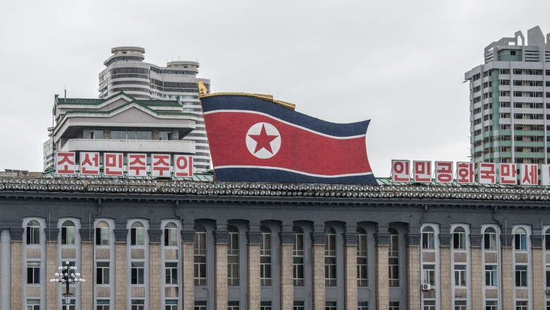 PYONGYANG, NORTH KOREA - AUGUST 23: Women walk across Kim Il-sung Square as a huge North Korea flag is displayed atop the Central Committee of the Workers' Party of Korea building, on August 23, 2018 in Pyongyang, North Korea. Despite ongoing international negotiations aimed at easing tensions on the Korean peninsula, the Democratic People's Republic of Korea remains the most isolated and secretive nation on earth. Since it's formation in 1948 the country has been led by the Kim dynasty, a three-generation lineage of North Korean leadership descended from the country's first leader, Kim Il-sung followed by Kim Jong-il and grandson and current leader, Kim Jong-un. Although major hostilities ceased with the signing of the Armistice in 1953, the two Koreas have remained technically at war and the demilitarised zone along the border continues to be the most fortified border in the world. (Photo by Carl Court/Getty Images)