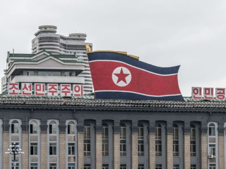 PYONGYANG, NORTH KOREA - AUGUST 23: Women walk across Kim Il-sung Square as a huge North Korea flag is displayed atop the Central Committee of the Workers' Party of Korea building, on August 23, 2018 in Pyongyang, North Korea. Despite ongoing international negotiations aimed at easing tensions on the Korean peninsula, the Democratic People's Republic of Korea remains the most isolated and secretive nation on earth. Since it's formation in 1948 the country has been led by the Kim dynasty, a three-generation lineage of North Korean leadership descended from the country's first leader, Kim Il-sung followed by Kim Jong-il and grandson and current leader, Kim Jong-un. Although major hostilities ceased with the signing of the Armistice in 1953, the two Koreas have remained technically at war and the demilitarised zone along the border continues to be the most fortified border in the world. (Photo by Carl Court/Getty Images)