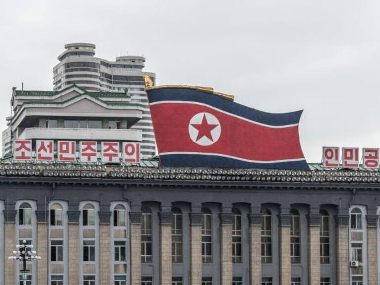 PYONGYANG, NORTH KOREA - AUGUST 23: Women walk across Kim Il-sung Square as a huge North Korea flag is displayed atop the Central Committee of the Workers&#039; Party of Korea building, on August 23, 2018 in Pyongyang, North Korea. Despite ongoing international negotiations aimed at easing tensions on the Korean peninsula, the Democratic People&#039;s Republic of Korea remains the most isolated and secretive nation on earth. Since it&#039;s formation in 1948 the country has been led by the Kim dynasty, a three-generation lineage of North Korean leadership descended from the country&#039;s first leader, Kim Il-sung followed by Kim Jong-il and grandson and current leader, Kim Jong-un. Although major hostilities ceased with the signing of the Armistice in 1953, the two Koreas have remained technically at war and the demilitarised zone along the border continues to be the most fortified border in the world. (Photo by Carl Court/Getty Images)