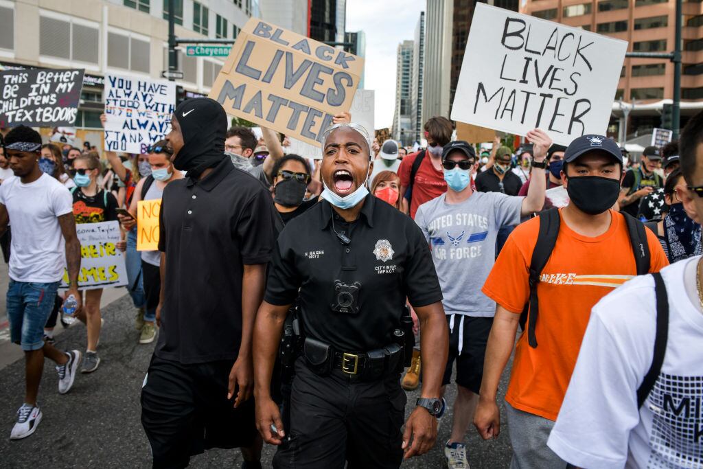 DENVER, CO - JUNE 01: Denver Police officer Nate Magee chants with protestors marching during the fifth consecutive day of demonstrations in the aftermath of the death of George Floyd on June 1, 2020 in Denver, Colorado. Protests continue in cities across the country after Floyd, a black man, died in police custody in Minneapolis on May 25. (Photo by Michael Ciaglo/Getty Images)