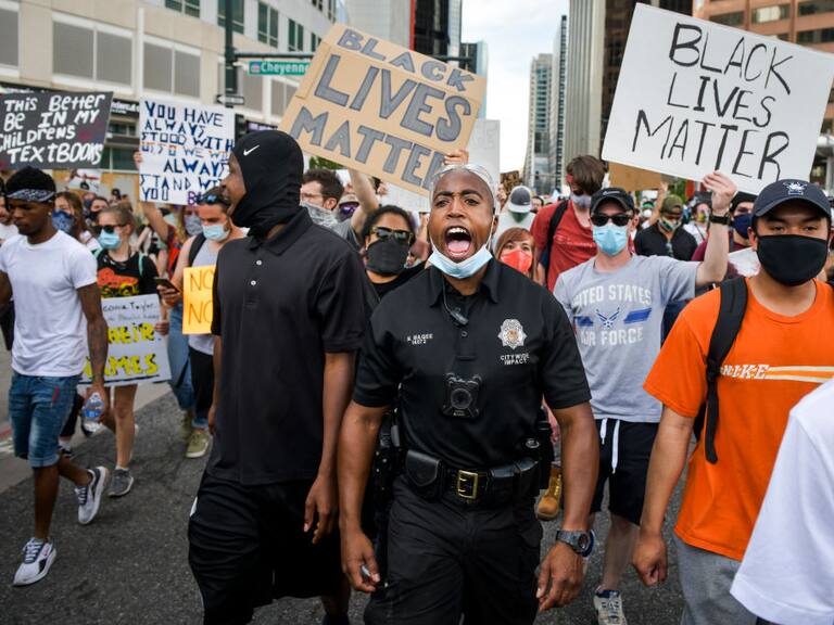 DENVER, CO - JUNE 01: Denver Police officer Nate Magee chants with protestors marching during the fifth consecutive day of demonstrations in the aftermath of the death of George Floyd on June 1, 2020 in Denver, Colorado. Protests continue in cities across the country after Floyd, a black man, died in police custody in Minneapolis on May 25. (Photo by Michael Ciaglo/Getty Images)