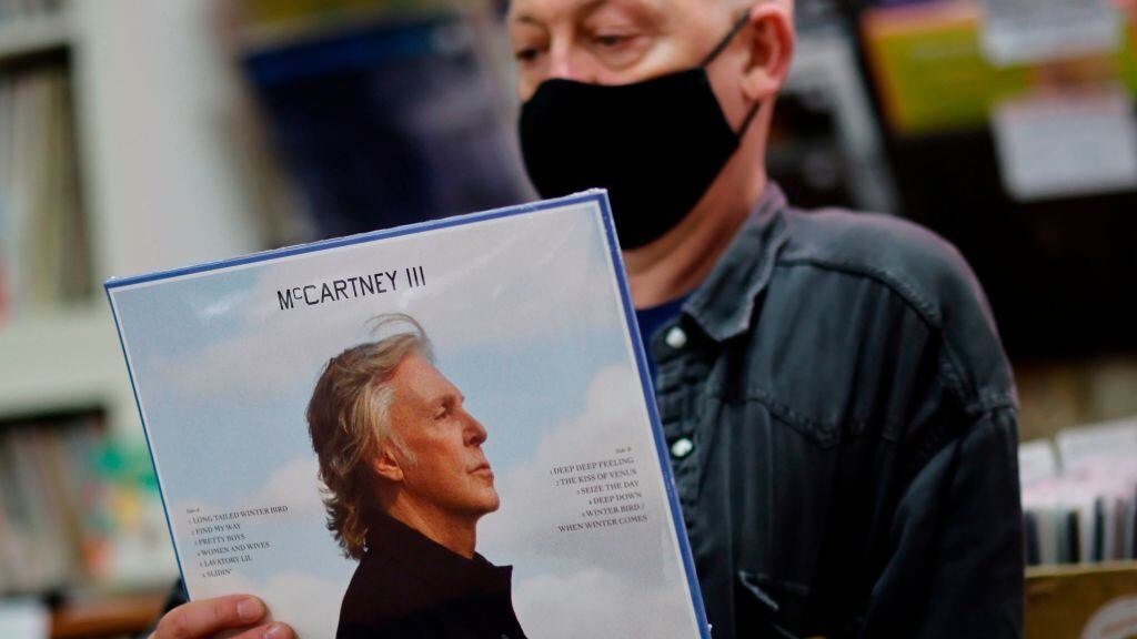 Karl Shale poses with a copy of the newly released album McCartney III by British musician Paul McCartney in the Sounds of Universe record store in London on December 18, 2020. (Photo by Tolga Akmen / AFP) (Photo by TOLGA AKMEN/AFP via Getty Images)