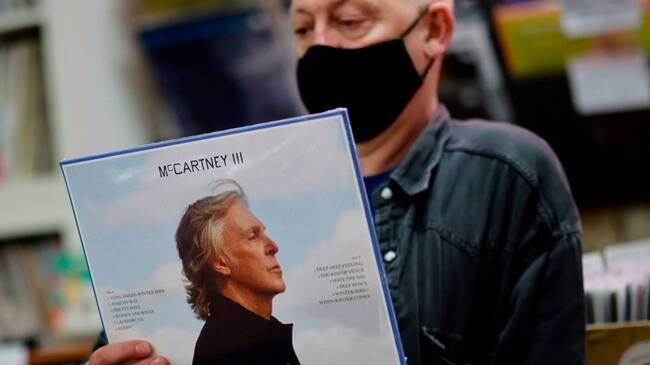 Karl Shale poses with a copy of the newly released album McCartney III by British musician Paul McCartney in the Sounds of Universe record store in London on December 18, 2020. (Photo by Tolga Akmen / AFP) (Photo by TOLGA AKMEN/AFP via Getty Images)