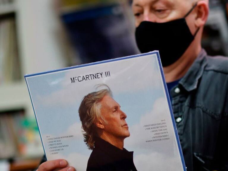 Karl Shale poses with a copy of the newly released album McCartney III by British musician Paul McCartney in the Sounds of Universe record store in London on December 18, 2020. (Photo by Tolga Akmen / AFP) (Photo by TOLGA AKMEN/AFP via Getty Images)