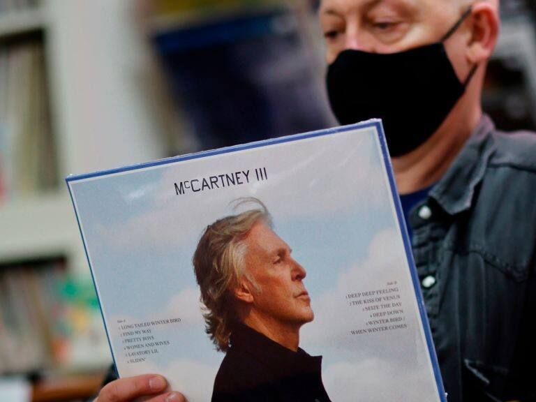 Karl Shale poses with a copy of the newly released album McCartney III by British musician Paul McCartney in the Sounds of Universe record store in London on December 18, 2020. (Photo by Tolga Akmen / AFP) (Photo by TOLGA AKMEN/AFP via Getty Images)