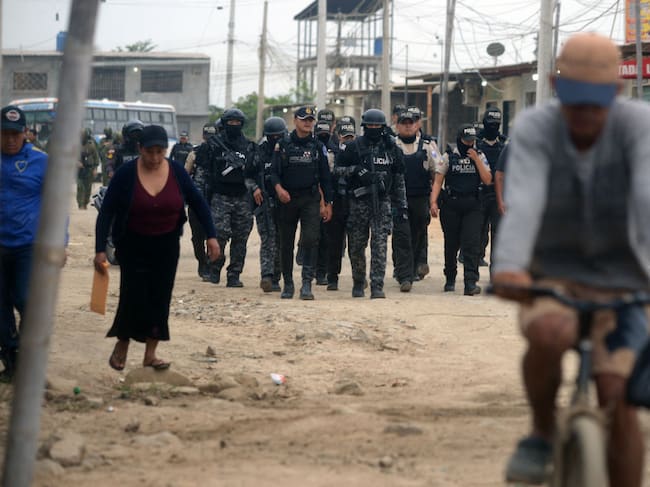 Policías y militares ingresan a un barrio carenciado en la ciudad de Durán en Ecuador.