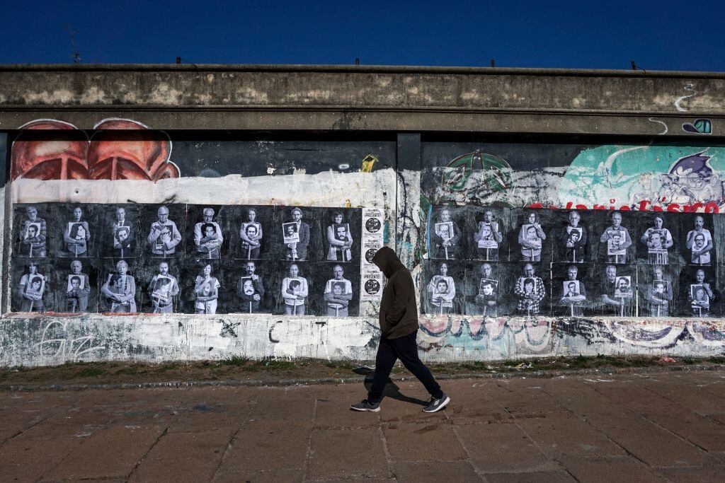 Mujer camina ante un recuerdo de los crímenes de la dictadura en Uruguay