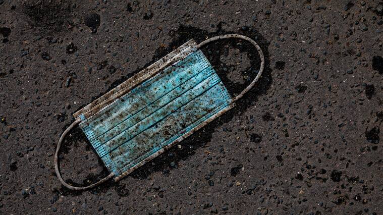 06 April 2021, Lower Saxony, Hanover: A heavily soiled medical mask lies on the asphalt. Photo: Moritz Frankenberg/dpa (Photo by Moritz Frankenberg/picture alliance via Getty Images)