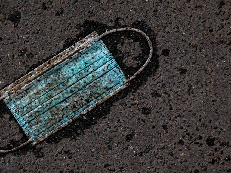 06 April 2021, Lower Saxony, Hanover: A heavily soiled medical mask lies on the asphalt. Photo: Moritz Frankenberg/dpa (Photo by Moritz Frankenberg/picture alliance via Getty Images)