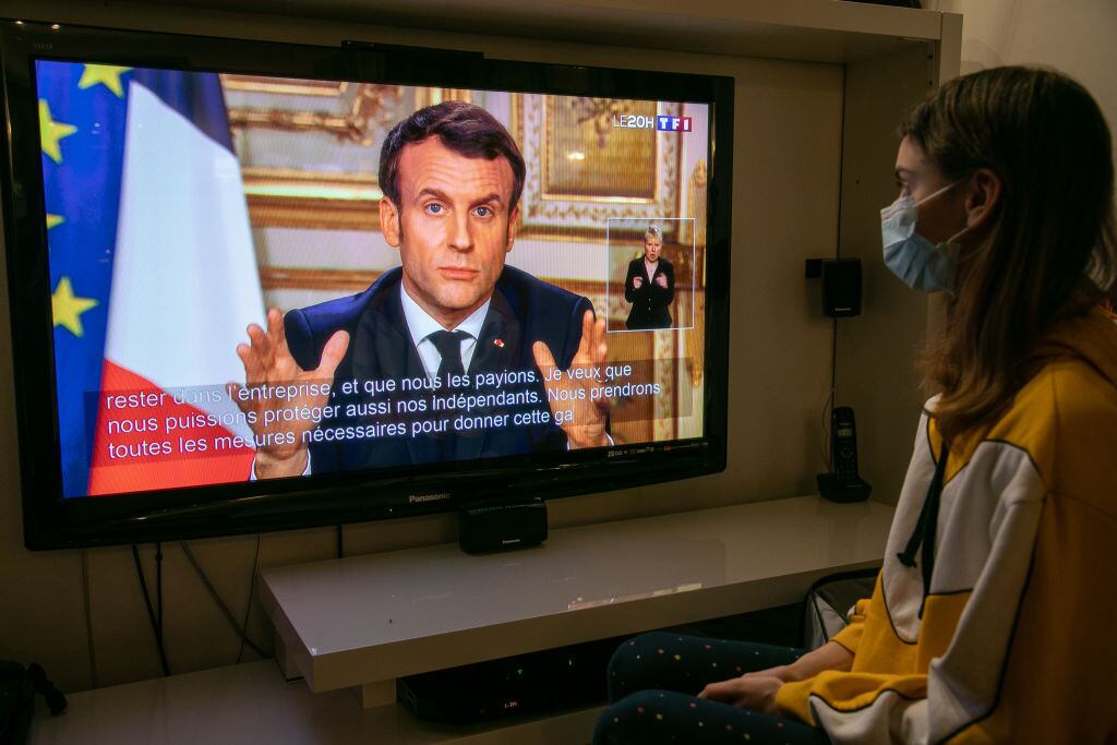 Una televidente observa el mensaje del gobernante francés Emmanuel Macron
