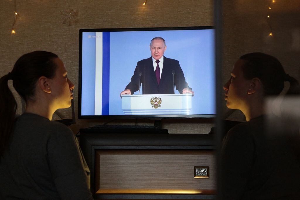 Mujer mira un mensaje en televisión del presidente de Rusia Vladimir Putin