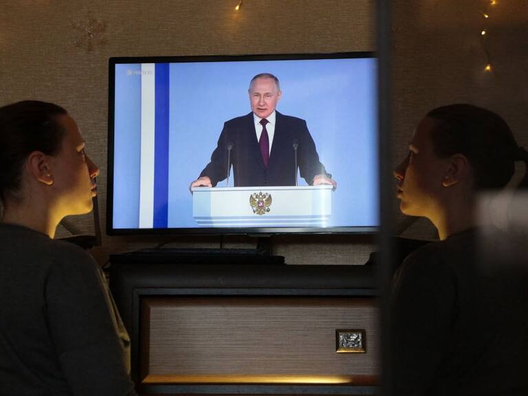 Mujer mira un mensaje en televisión del presidente de Rusia Vladimir Putin