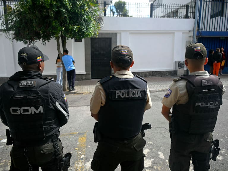 Un grupo de policías de Ecuador vigila desde la calle los accesos a la embajada de México en la ciudad de Quito.