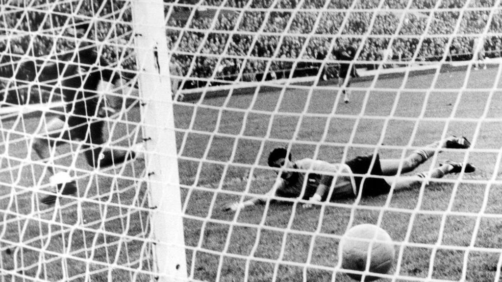 Chilean forward Ramirez (L) defeats Italian goalkeeper Mattrel, who lies flat on the ground, and scores the 1-0 goal during the 1962 World Cup game Chile against Italy at the National Stadium in Santiago de Chile, Chile, 2 June 1962. Chile won the game 2-0 in front of 66,000 spectators. The game was considered to be a scandal due to the continues series of fouls and assaults on the pitch which disrupted the game. Two Italian players were sent off whereby one player only left when police officers escorted him off the pitch. (Photo by -/picture alliance via Getty Images)