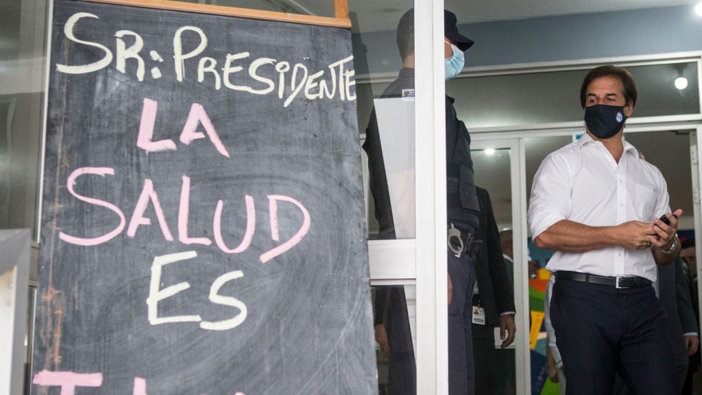 MONTEVIDEO, URUGUAY - MARCH 29: President of Uruguay Luis Lacalle Pou leaves Hospital Maciel walking by a banner that reads in Spanish "Mr President, health is unhealthy" after receiving the first dose of the Sinovac vaccine on March 29, 2021 in Montevideo, Uruguay. (Photo by Ernesto Ryan/Getty Images)