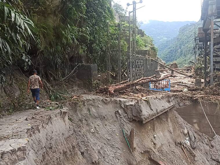 Hombre mira un camino destruido tras las graves inundaciones en India