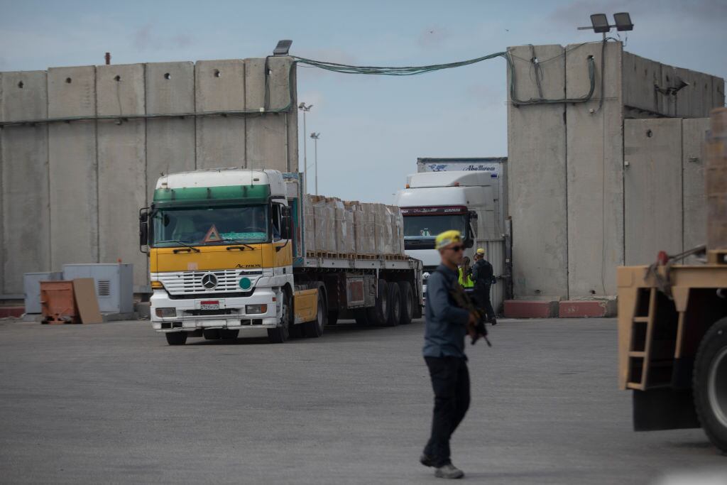 Trabajadores humanitarios supervisan el acceso de un camión con ayuda para la Franja de Gaza, el que antes es revisado en el cruce Kerem Shalom.