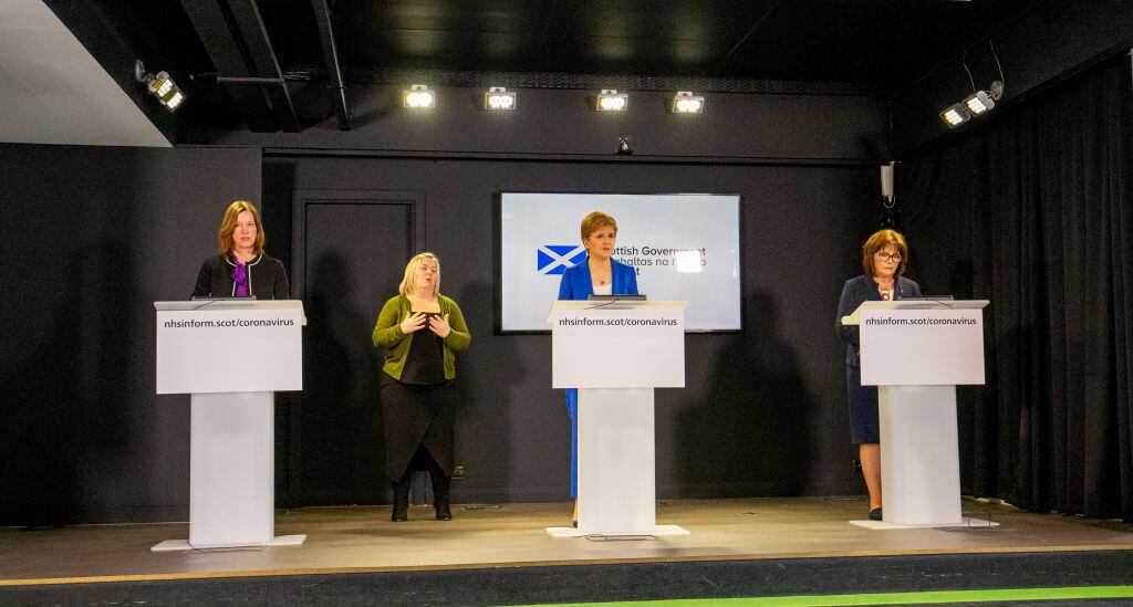 Calderwood en conferencia junto a la primera ministra Nicola Sturgeon y la ministra de salud Jeane Freeman