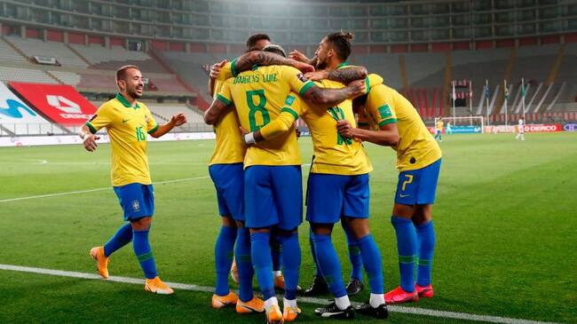 Brazil's players celebrate after teammate Neymar (covered) scored against Peru during their 2022 FIFA World Cup South American qualifier football match at the National Stadium in Lima, on October 13, 2020, amid the COVID-19 novel coronavirus pandemic. (Photo by Paolo Aguilar / POOL / AFP) (Photo by PAOLO AGUILAR/POOL/AFP via Getty Images)