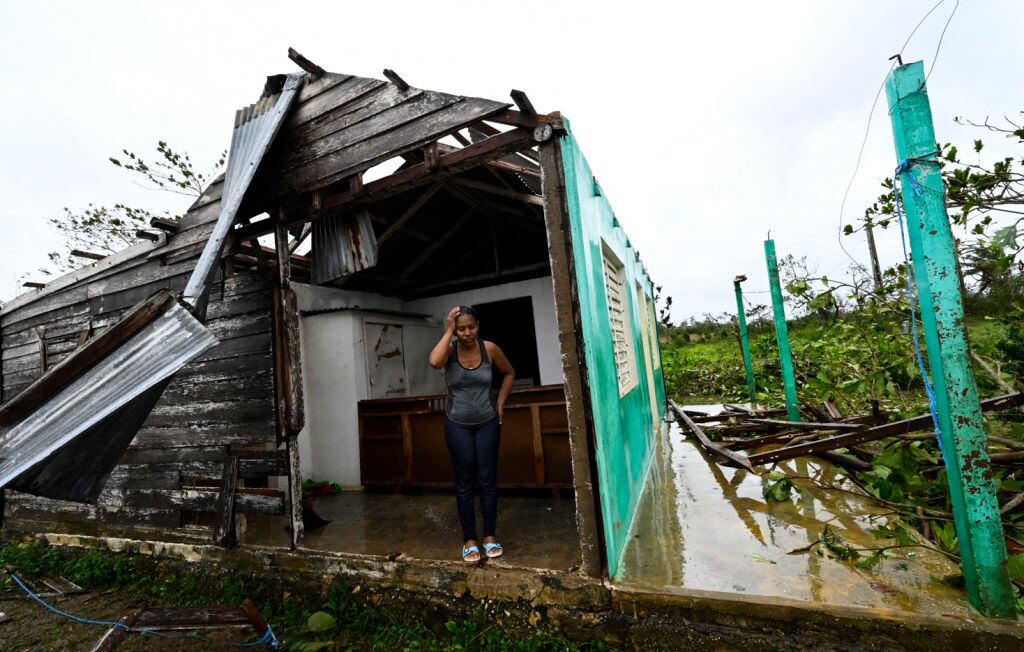 Una mujer frente a su hogar destruido por el huracán Ian en Cuba