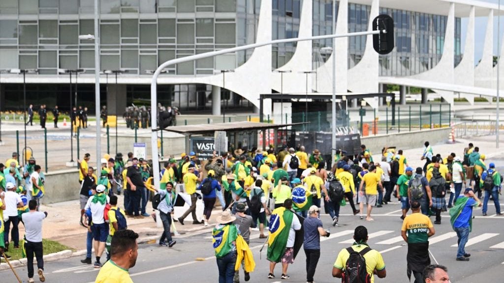 Supporters of Brazilian former President Jair Bolsonaro clash with the police during a demonstration outside the Planalto Palace in Brasilia on January 8, 2023. - Brazilian police used tear gas Sunday to repel hundreds of supporters of far-right ex-president Jair Bolsonaro after they stormed onto Congress grounds one week after President Luis Inacio Lula da Silva's inauguration, an AFP photographer witnessed. (Photo by EVARISTO SA / AFP) (Photo by EVARISTO SA/AFP via Getty Images)