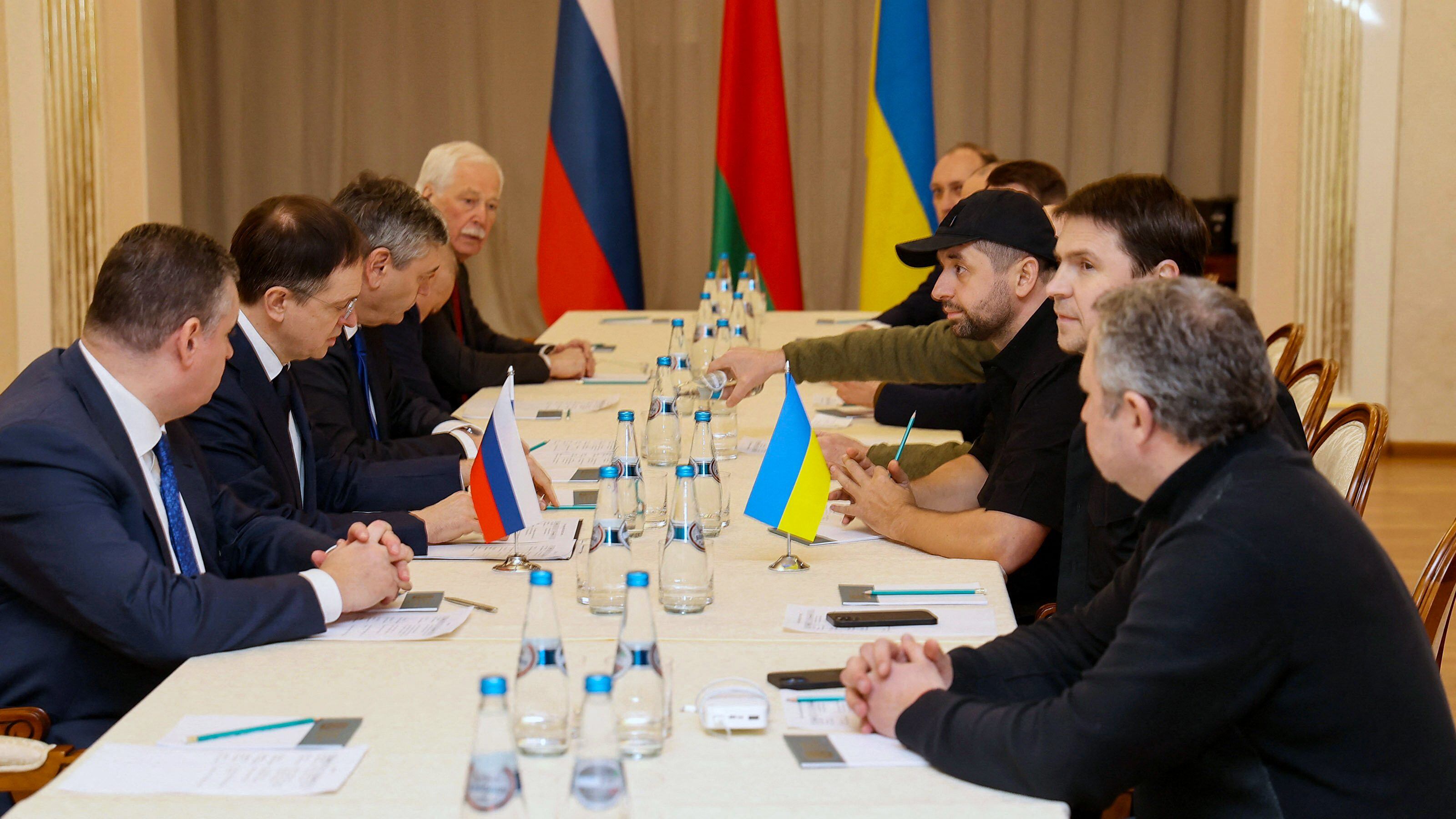 TOPSHOT - Members of delegations from Ukraine and Russia, including Russian presidential aide Vladimir Medinsky (2L), Ukrainian presidential aide Mykhailo Podolyak (2R), Volodymyr Zelensky's "Servant of the People" lawmaker Davyd Arakhamia (3R), hold talks in Belarus' Gomel region on February 28, 2022, following the Russian invasion of Ukraine. - Belarus OUT (Photo by Sergei KHOLODILIN / BELTA / AFP) / Belarus OUT (Photo by SERGEI KHOLODILIN/BELTA/AFP via Getty Images)