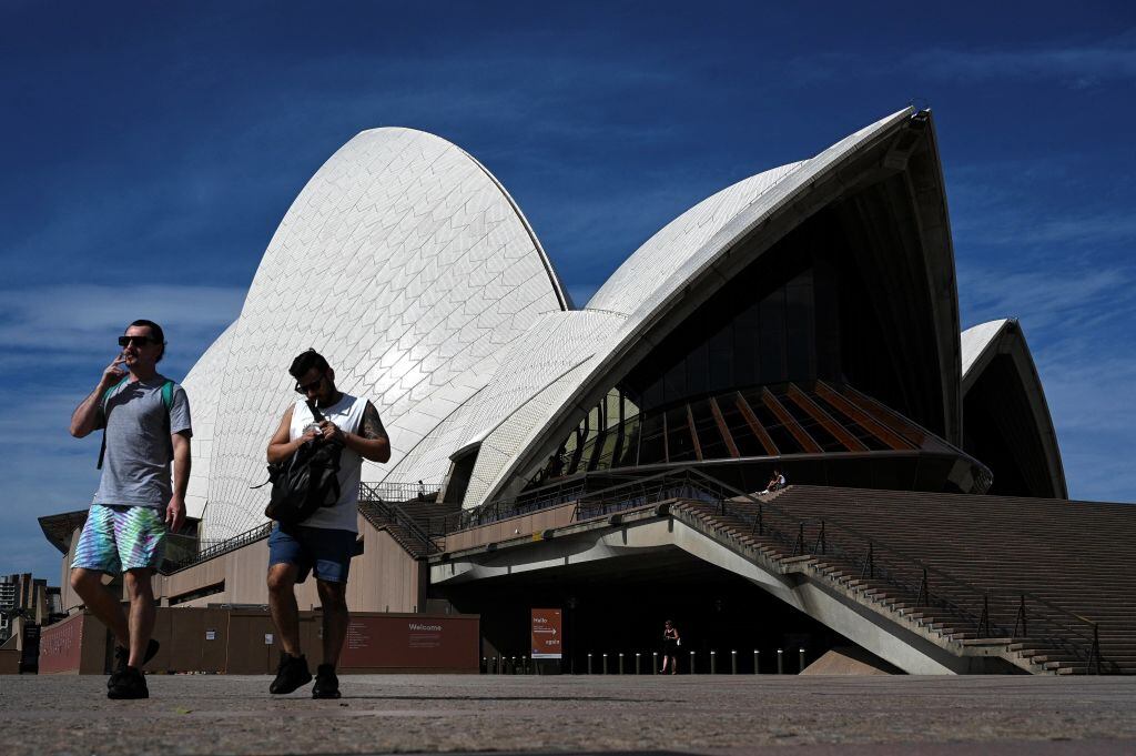 Australianos caminan frente a la Ópera de Sídney